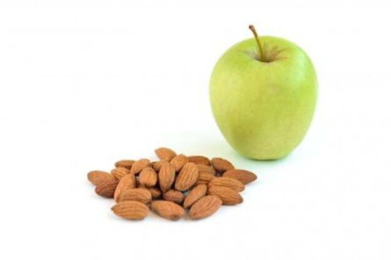 яблоко и горсть миндаля на тарелке