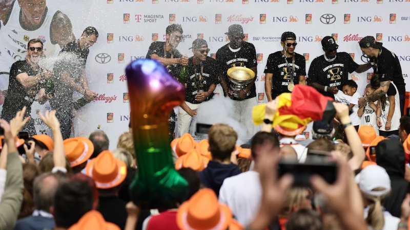 баскетболисты сборной Германии празднуют победу с трофеем